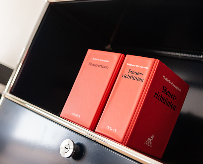 Rote Bücher zur Steuerberatung in einem Schrank
